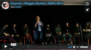 A vimeo video still showing a woman speaking into a microphone and 8 people seated behind her. The text reads "Keynote | Maggie Nichols | SGFA 2014 from CRiSAP"