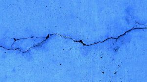 A blue wall with crack running through it
