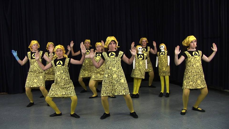 A performance photo of dancers in gold outfits