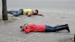 Two performers lying on the ground with microphones