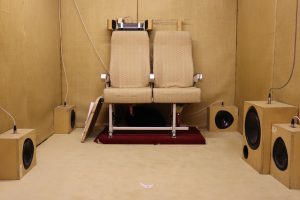 two airplane chairs and speakers in a room